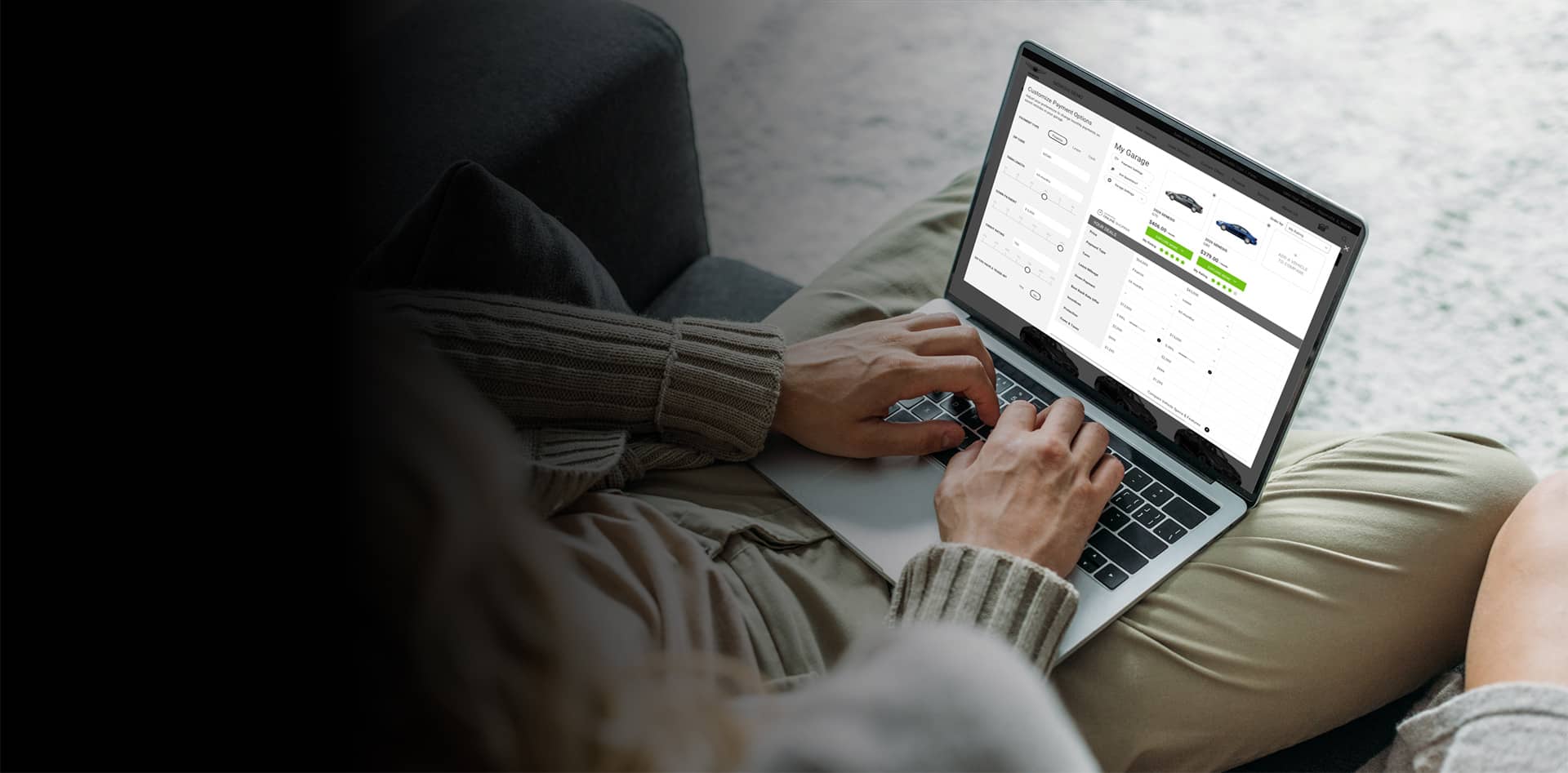 Person sitting on a couch using a laptop to browse car options. The screen displays car details, prices, and images. The setting is cozy with the person wearing a sweater and casual pants. The background is softly blurred, focusing on the laptop.