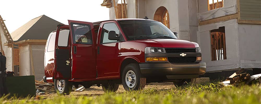 Chevrolet trucks parked at a construction site, featuring workers and a partially-built structure.