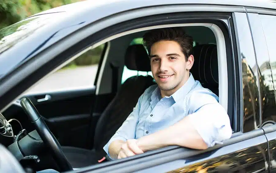 Person browsing car listings on a tablet with an orange coffee mug nearby.