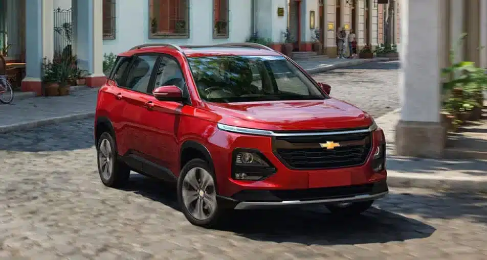 Red Chevrolet SUV parked on a cobblestone street, urban setting, modern design.