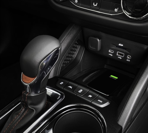 Car interior gear shift with USB, SD, and AUX ports, and a wireless charging pad.